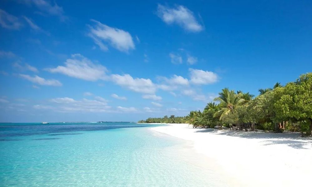 Bãi biển Đà Nẵng Xuân Thiều yên bình với bờ cát vàng, thuyền thúng và núi đồi xanh biếc phía xa